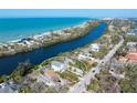 Expansive aerial shot showcases the home's location on a waterway near the beach, framed by lush Florida landscape at 8258 Midnight Pass Rd, Sarasota, FL 34242