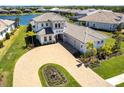 Aerial view of a two-story home showcasing the paver driveway, and landscaping around the property at 8265 Pavia Way, Bradenton, FL 34202