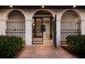 Arched gate and doorway leading to the home's entry, surrounded by manicured landscaping at 875 Siesta Key Cir, Sarasota, FL 34242