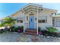 Inviting home entrance with blue door, brick steps, stone pathway, and well-manicured landscaping at 12204 45Th Avenue W Dr, Cortez, FL 34215