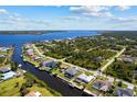 Stunning aerial view of a waterfront community with homes along canals leading to a vast open bay at 12396 Bacchus Rd, Port Charlotte, FL 33981