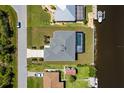 Aerial shot of a beautiful home with a private pool and waterfront access, surrounded by lush greenery at 12396 Bacchus Rd, Port Charlotte, FL 33981