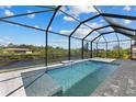 Inviting screened-in pool area with a clear, refreshing pool and peaceful waterfront views at 12396 Bacchus Rd, Port Charlotte, FL 33981