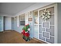 Charming condo entrance with potted flowers, decorative wreath, and a white screen door at 1323 Perico Point Cir # 107, Bradenton, FL 34209