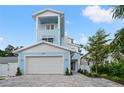 Charming light blue two-story home featuring a spacious two-car garage and a manicured front yard at 1647 Siesta Dr, Sarasota, FL 34239
