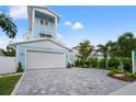 Beautiful light blue two-story home with a two-car garage and driveway at 1647 Siesta Dr, Sarasota, FL 34239