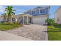 Beautiful two-story home with a paver driveway, covered porch, and well-manicured landscaping at 17966 Grand Prosperity Dr, Venice, FL 34293