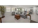 Bright open-concept living room with lake views, neutral decor, and tiled floors at 17966 Grand Prosperity Dr, Venice, FL 34293