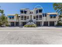 Beautiful condo building with blue awnings and well-maintained landscaping in a coastal setting at 1912 Harbourside Dr # 602, Longboat Key, FL 34228