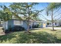 View of this single-story home's charming curb appeal, including mature trees and a well-maintained lawn at 2001 25Th W Ave, Bradenton, FL 34205