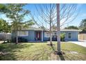 This single-story home features a well-manicured lawn, a red front door, and a welcoming exterior at 2001 25Th W Ave, Bradenton, FL 34205