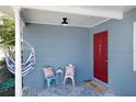 Inviting front porch featuring a red door, cozy seating, and stylish decor for a welcoming entrance at 2001 25Th W Ave, Bradenton, FL 34205
