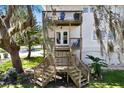 Multi-level wooden decks and stairs adorn the back of the white two-story home at 2003 12Th W Ave, Bradenton, FL 34205