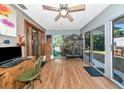 Bright sunroom featuring wood floors, sliding glass doors, and a ceiling fan for a cozy atmosphere at 2070 59Th St, Sarasota, FL 34243