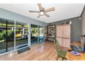 Bright sunroom featuring wood floors, sliding glass doors, and a ceiling fan for a cozy atmosphere at 2070 59Th St, Sarasota, FL 34243