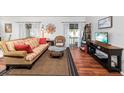 Cozy living room with hardwood floors, decorative wall art, and sliding doors leading to outdoor balcony at 2224 Bahia Vista St # E6, Sarasota, FL 34239