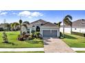 Charming single-story home with lovely landscaping and a brick driveway leading to a two-car garage at 25325 Longmeadow Dr, Punta Gorda, FL 33955