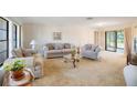 Bright living room featuring neutral carpeting, comfortable seating, and large windows at 3640 Aster Dr, Sarasota, FL 34233