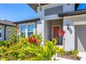 Inviting front entrance with colorful landscaping surrounding the walkway and a modern gray exterior at 3663 Quiet Dr, Sarasota, FL 34240
