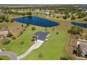 Aerial view of a well-maintained home on a large lawn with a pond and beautiful countryside in the background at 4606 Lake Fox Pl, Parrish, FL 34219