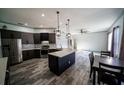 Modern kitchen featuring dark cabinets, stainless steel appliances, and a central island at 4706 Cayo Costa Pl, Bradenton, FL 34203