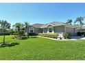 Charming gray home with lush green grass, trimmed bushes, and a well-maintained exterior at 5223 Chase Oaks Dr, Sarasota, FL 34241