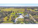 Sprawling estate with a long driveway, a beautiful pond, a large home, and plenty of green space surrounded by a white fence at 9902 284Th St E E St, Myakka City, FL 34251