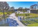 Long paved driveway leads to the house and a large garage surrounded by well-manicured landscaping and a gated entrance at 9902 284Th St E E St, Myakka City, FL 34251