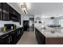 Spacious kitchen featuring granite countertops, black appliances, and an island with a sink at 108 San Avellino Ct, Bradenton, FL 34208