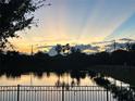 Sunset over a serene pond reflecting palm trees and sky, seen from the property at 108 San Avellino Ct, Bradenton, FL 34208