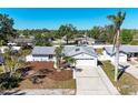 An aerial view of a single-story home with a two-car garage, driveway, palm trees, and a manicured front lawn at 1112 67Th Nw St, Bradenton, FL 34209