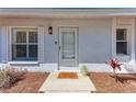 Close-up of a welcoming front door with sidelight windows and a 'stay awhile' doormat on the entryway at 1112 67Th Nw St, Bradenton, FL 34209