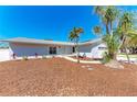 Inviting single-story home with a beautifully landscaped front yard, featuring palm trees, and a well-maintained lawn at 1112 67Th Nw St, Bradenton, FL 34209