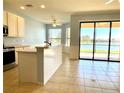 Bright open kitchen with island, stainless appliances, and views of the lake at 11331 Bertolini Dr, Venice, FL 34292