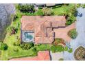 Aerial view of the estate with a private pool, tile roof, landscaping, and proximity to a serene lake at 13708 Red Rock Pl, Lakewood Ranch, FL 34202