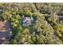 Secluded home with pool nestled within a lush green forest, featuring a long driveway and complete privacy at 13955 Pine Woods E Ln, Sarasota, FL 34240