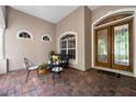 Inviting front porch features brick flooring, outdoor seating, and an elegant front door at 13955 Pine Woods E Ln, Sarasota, FL 34240