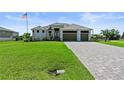 Beautiful single-story home with three-car garage, manicured lawn, and brick paved driveway at 16768 San Edmundo Rd, Punta Gorda, FL 33955