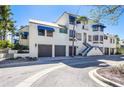 Modern condo building featuring a two-car garage, blue awnings, and meticulous landscaping at 1928 Harbourside Dr # 1403, Longboat Key, FL 34228