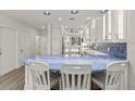 Bright kitchen features modern white cabinetry, blue backsplash, and breakfast bar seating at 1928 Harbourside Dr # 1403, Longboat Key, FL 34228