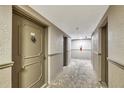 Hallway view features unit door, F104, with unique door knocker, fire extinguisher, and neutral colors at 2100 Benjamin Franklin Dr # 104, Sarasota, FL 34236