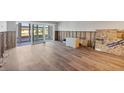 Spacious living room with new wood-look tile floors and sliding glass doors to the outside at 2100 Benjamin Franklin Dr # 104, Sarasota, FL 34236