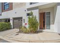 Modern townhome exterior boasts a garage, sleek front door, and vibrant plants, enhancing curb appeal at 232 Cosmopolitan Ct, Sarasota, FL 34236