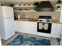 Bright kitchen featuring white cabinets, butcher block countertops, and open shelving at 2601 Gulf N Dr # 221, Bradenton Beach, FL 34217