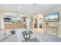 Open-concept living room with tile floors, neutral colors, and sightlines to the kitchen and bedroom at 2728 Trinidad St, Sarasota, FL 34231