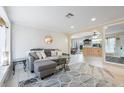 Well-lit living room with geometric wallpaper, contemporary furniture, and view of kitchen at 2728 Trinidad St, Sarasota, FL 34231