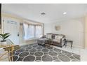 Cozy living room featuring a large window seat, stylish decor, and ample natural light at 2728 Trinidad St, Sarasota, FL 34231