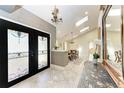 Bright foyer with tile flooring, skylights, and a decorative glass door, leads to the dining room at 3111 Bayou Sound, Longboat Key, FL 34228