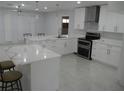 Bright kitchen with stainless steel appliances, white cabinets, and an island with bar stool seating at 361 Yorkshire St, Port Charlotte, FL 33954