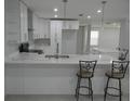 Bright kitchen with stainless steel appliances, white cabinets, and a bar counter with elegant seating at 361 Yorkshire St, Port Charlotte, FL 33954